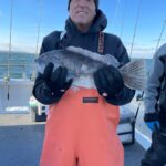 a person holding a fish posing for the camera