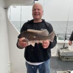 a man holding a fish on a boat