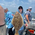a group of people standing next to a person holding a fish