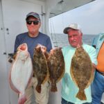 a group of people standing next to a man holding a fish