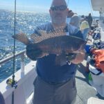 a man holding a fish in the water