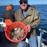 a man standing next to a body of water