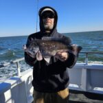a person holding a fish on a boat in a body of water