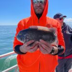 a man holding a fish in the water