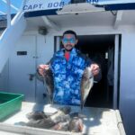 a man holding a fish on a boat