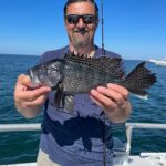 a man holding a fish in the water