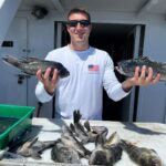 a man holding a fish in front of a building