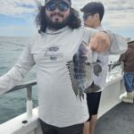 a man holding a fish in the water