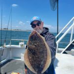 a man holding a fish on a boat
